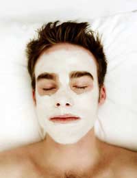 man with eyes closed, relaxing with herbal face mask.
